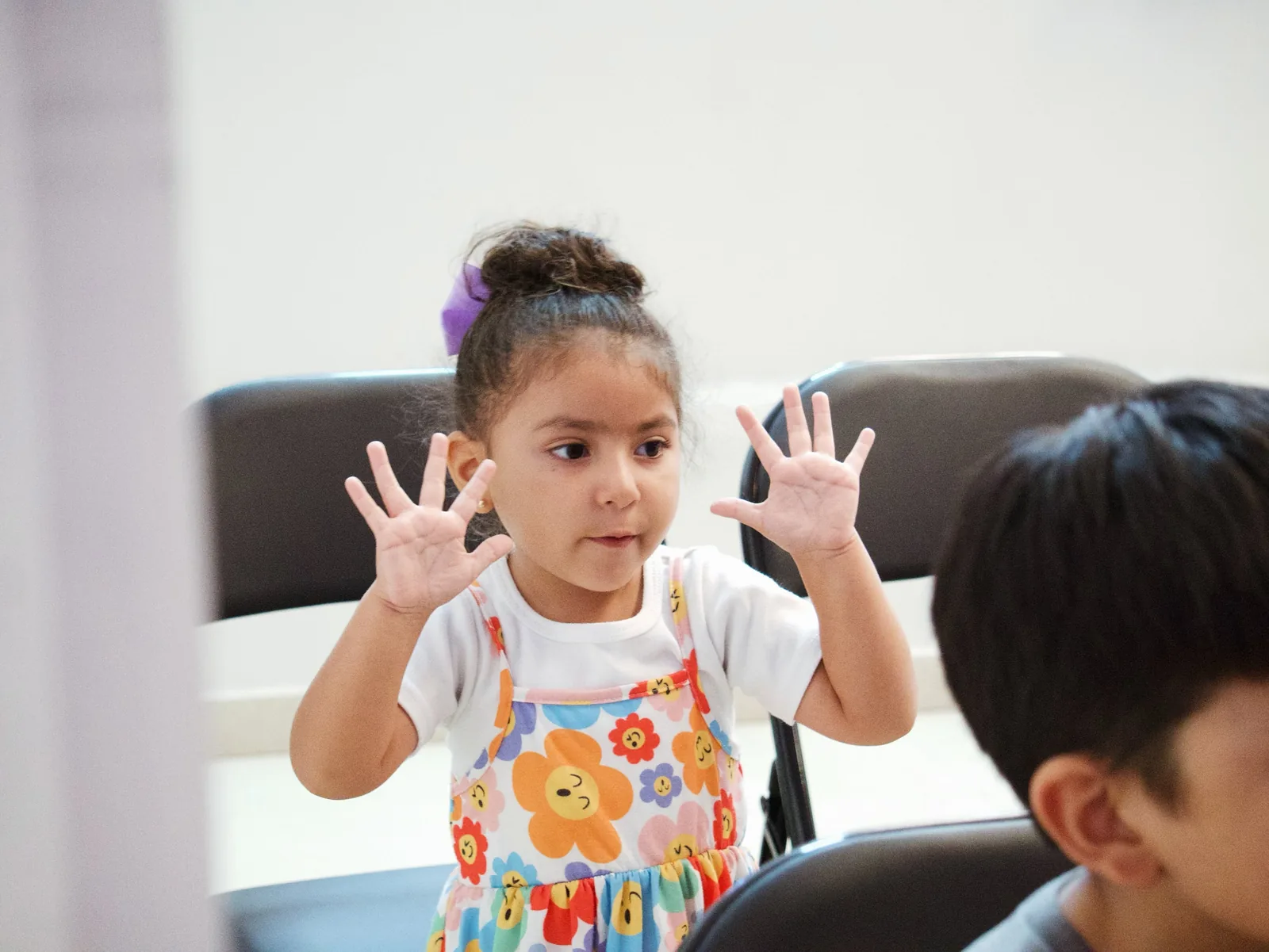 A little girl with her hands raised